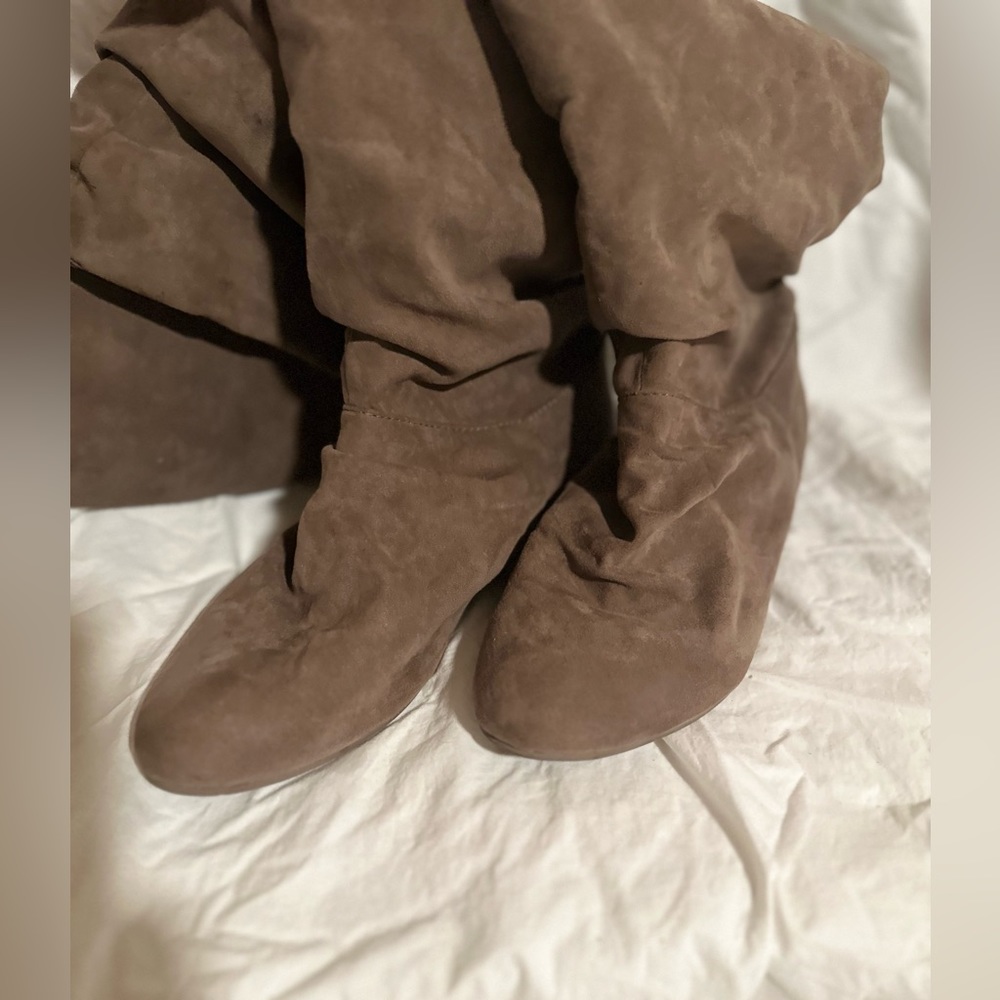 Brown suede lightly worn knee high boots.